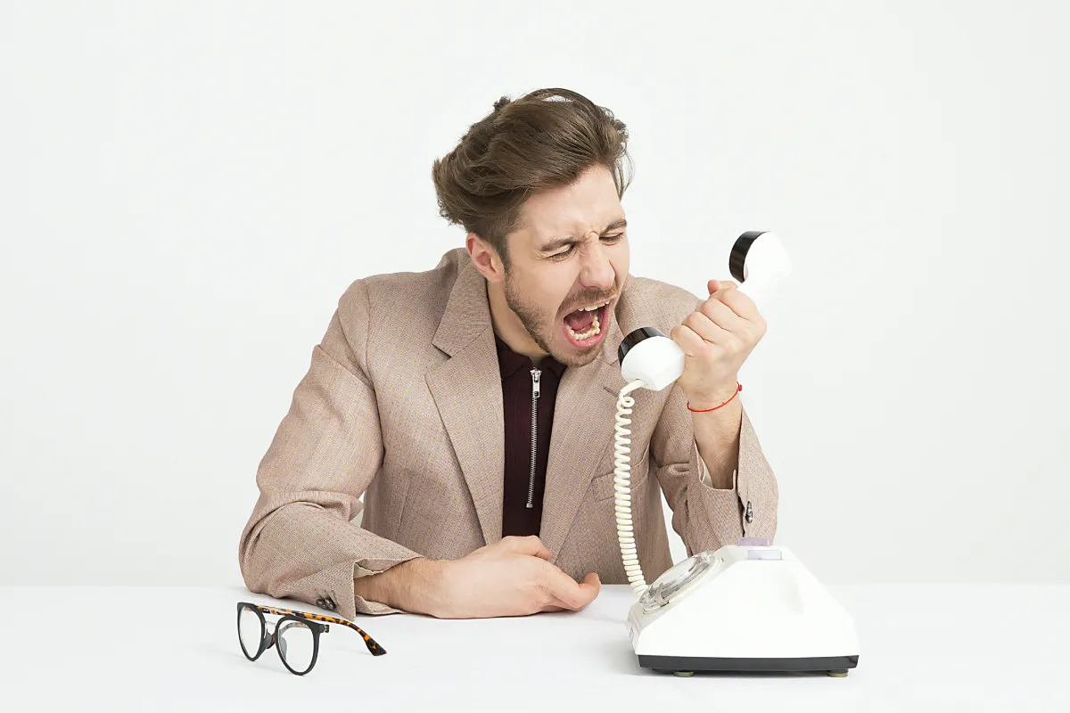 Ein Vertriebsmitarbeiter schreit genervt ins Telefon
